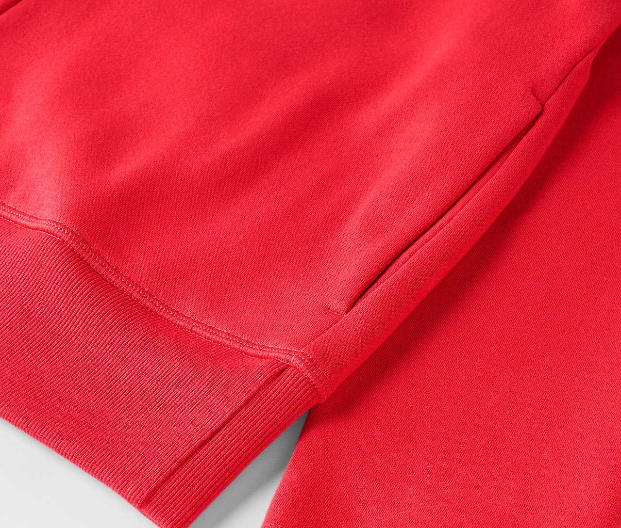 Szczegół czerwonej bluzy z kapturem ze ściągaczem.