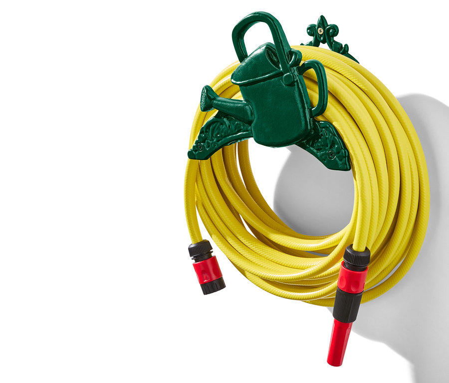 Żółty wąż ogrodowy zwinięty na ciemnozielonym uchwycie w kształcie konewki.