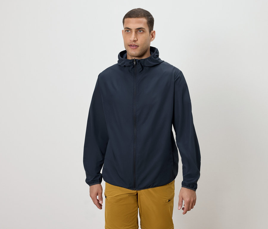 Mężczyzna ma na sobie granatową kurtkę z kapturem i złote szorty.