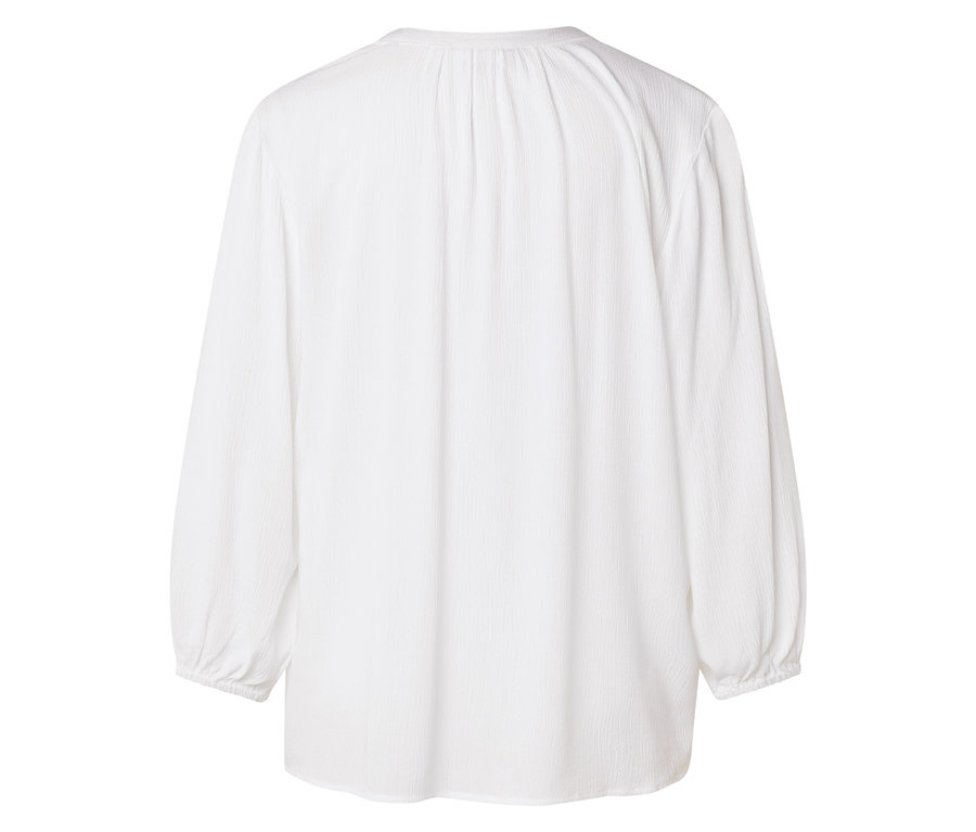 Tył białej bluzki z długim rękawem.