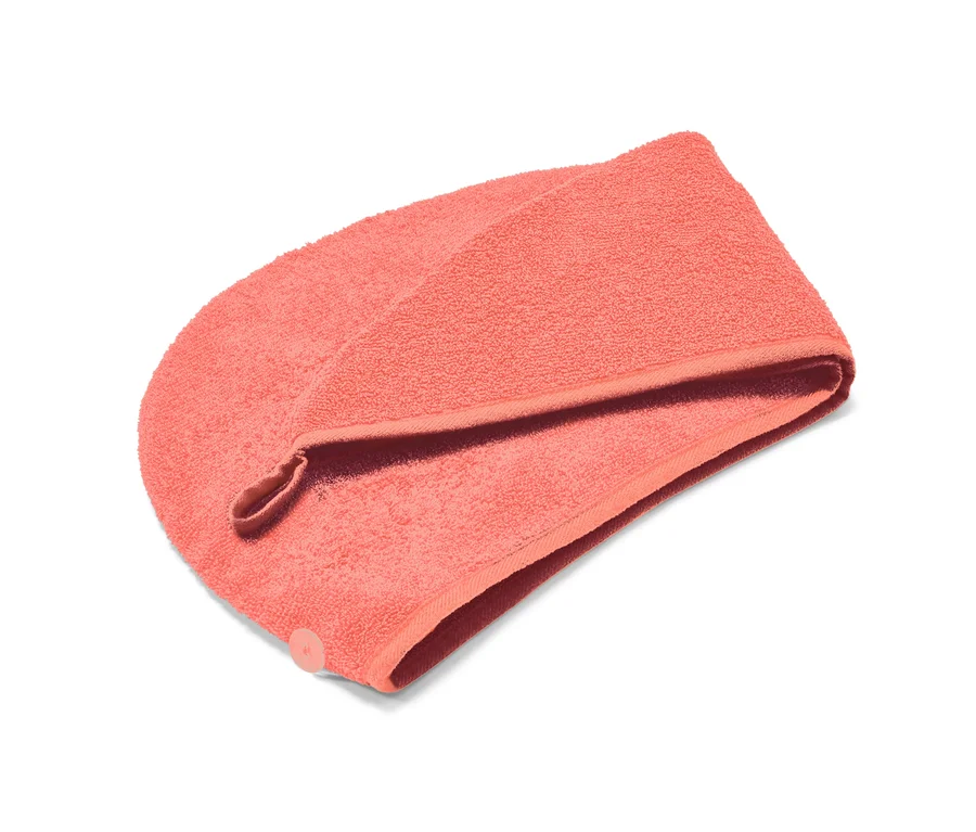 Koralowy ręcznik z turbanem na białym tle.
