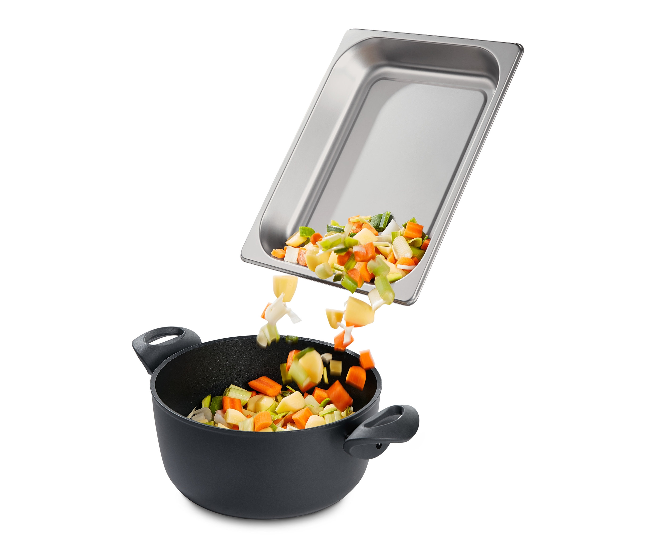 Kostki warzyw wpadają z metalowej miski do garnka.