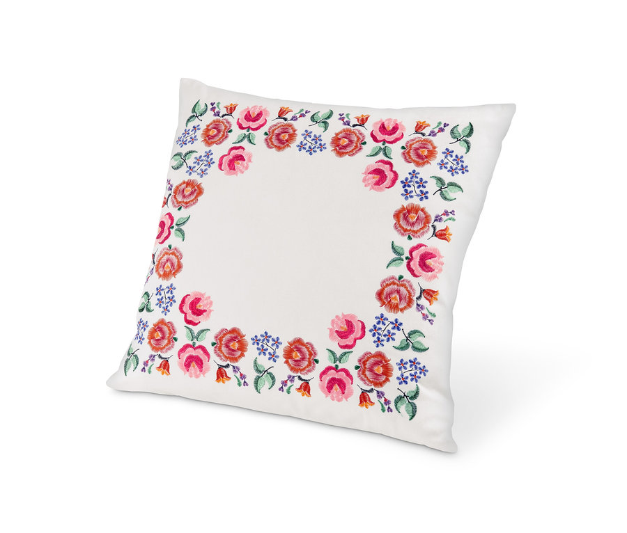 Dekoracyjna poduszka z wypełnieniem, ozdobiona haftem z różowych i fioletowych kwiatów.