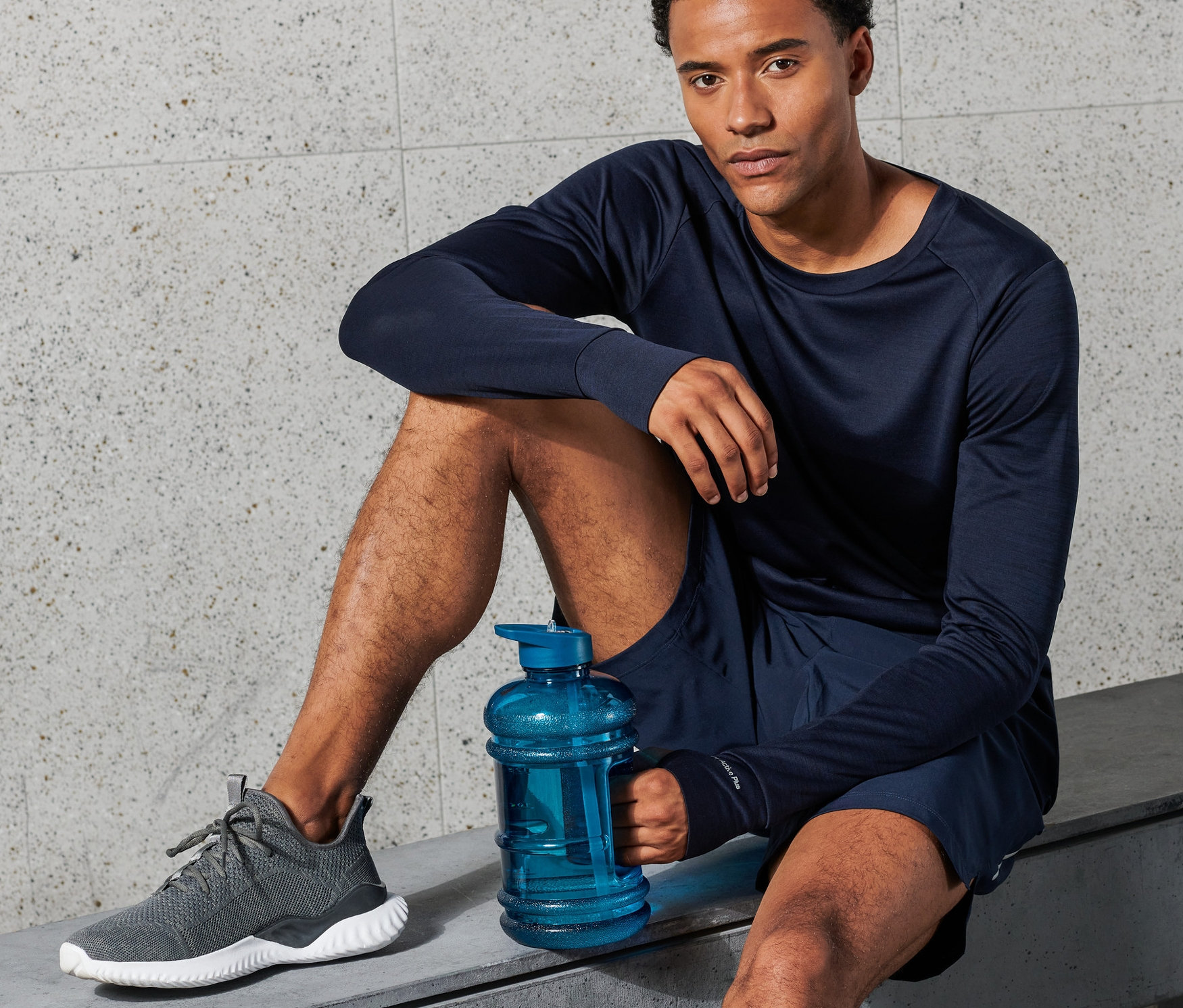 Mężczyzna siedzi na ławce i trzyma niebieski bidon XXL.