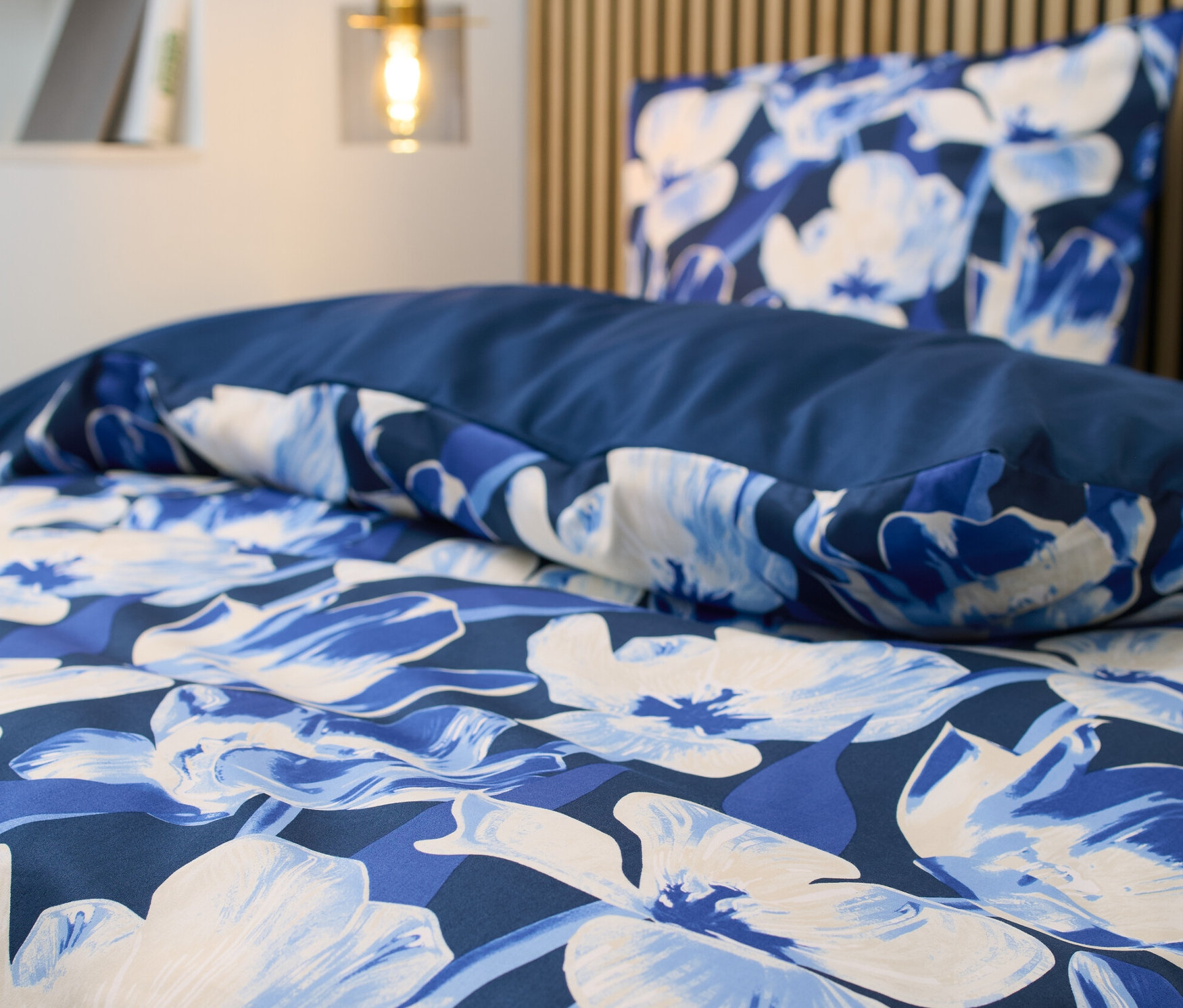 Zbliżenie na satynową pościel w kwiaty w standardowym rozmiarze.