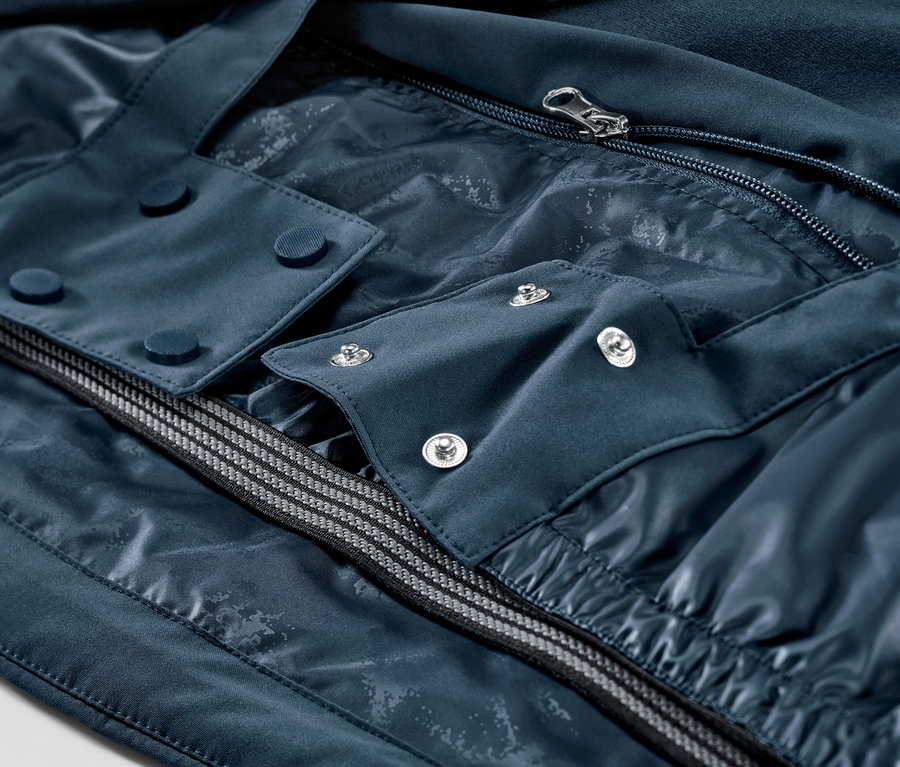 Zbliżenie granatowej kurtki narciarskiej z zamkiem błyskawicznym i guzikami.