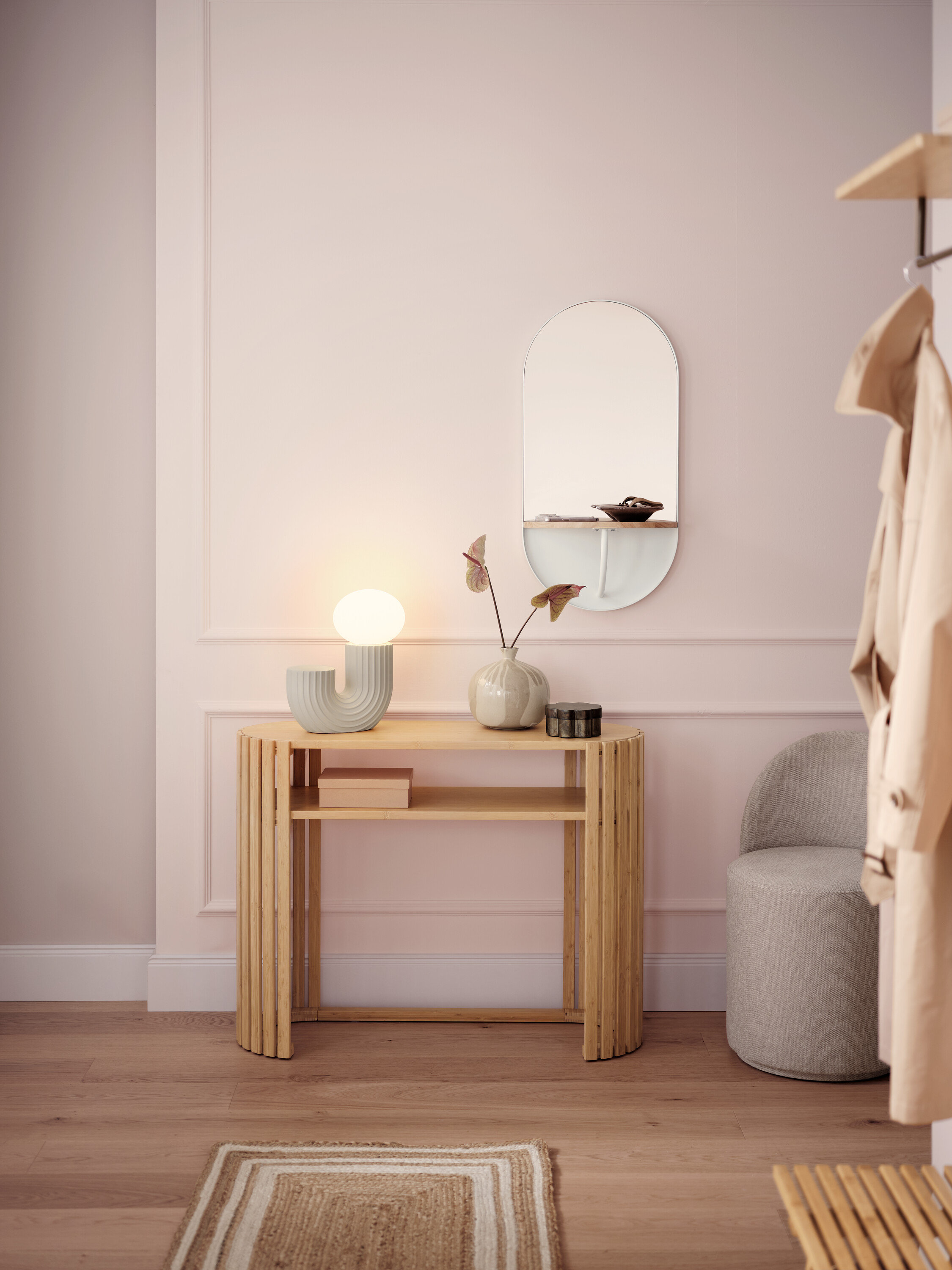 Jasny korytarz z drewnianym stolikiem konsolowym, lampą, lustrem i szarym stołkiem.