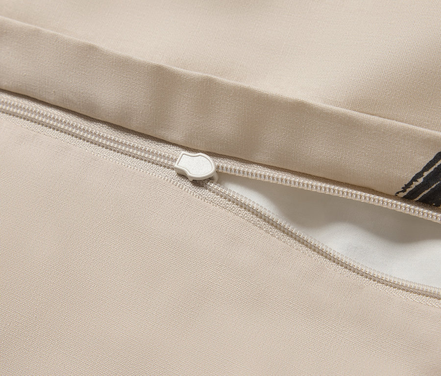 Zbliżenie na beżową poszwę na kołdrę z zamkiem błyskawicznym.