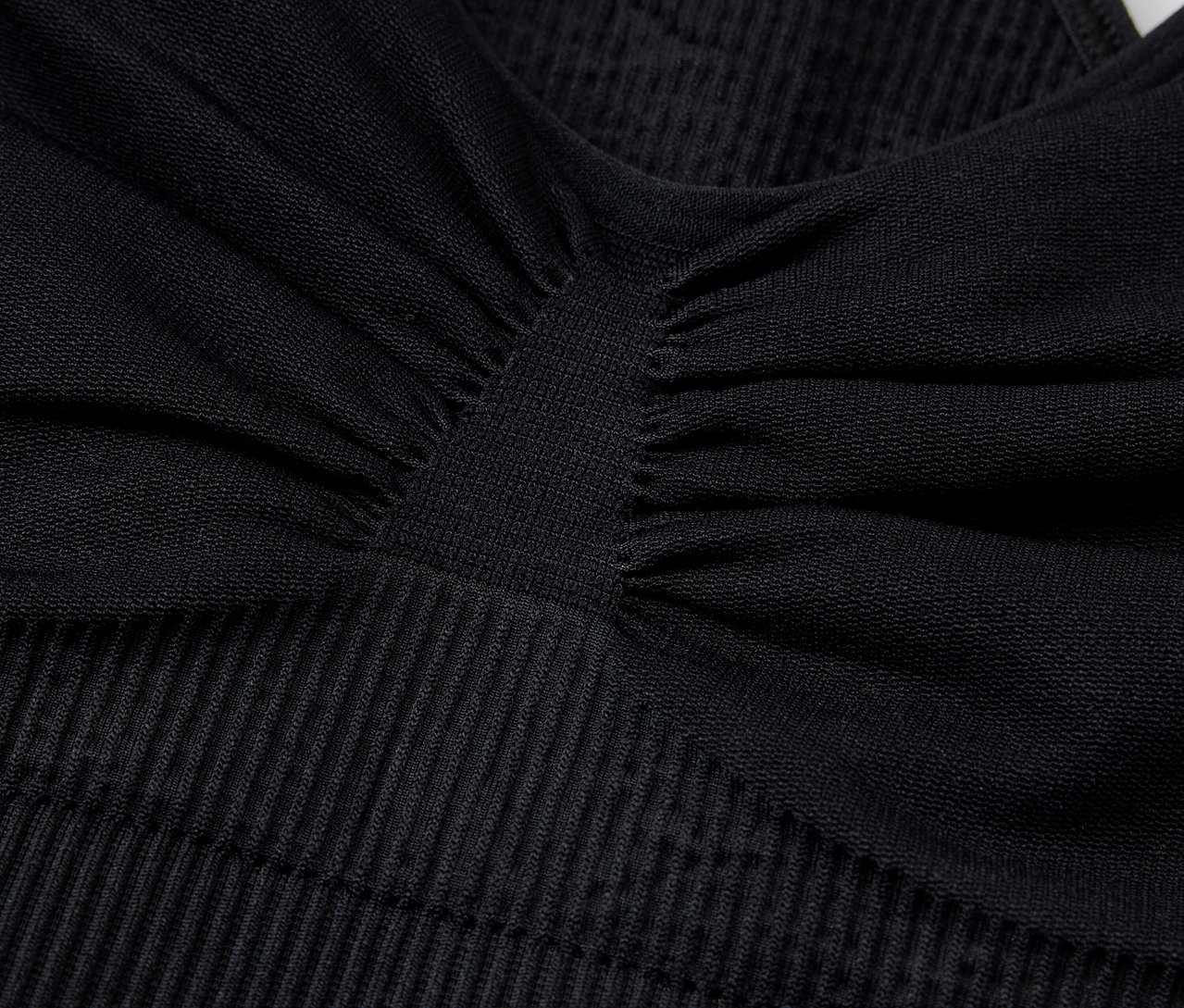 Szczegółowe ujęcie czarnego, teksturowanego biustonosza sportowego.