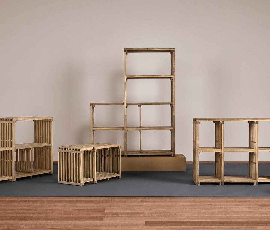 Cztery drewniane regały o różnych rozmiarach na szarej podkładce na drewnianej podłodze.