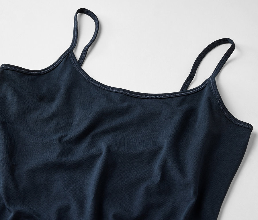 Zbliżenie na granatowy damski top na ramiączkach na jasnym tle.