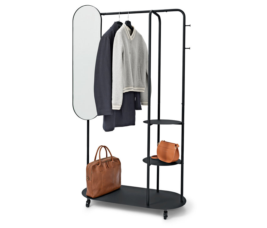 Czarny stojak na ubrania z owalnym lustrem, płaszczem, swetrem, spodniami i dwiema brązowymi torbami.