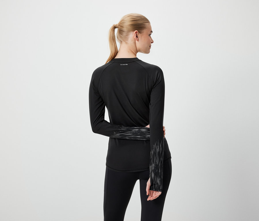 Blondynka z kucykiem w czarnym stroju sportowym, widziana z tyłu.