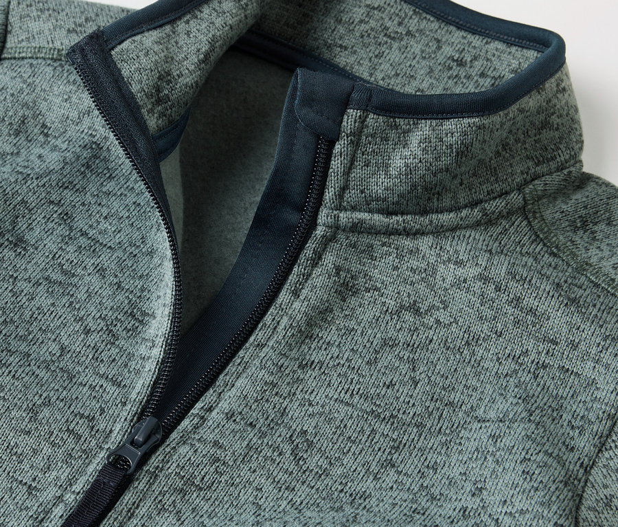 Zbliżenie na rozpiętą kurtkę hybrydową z dzianiny polarowej dla dzieci.