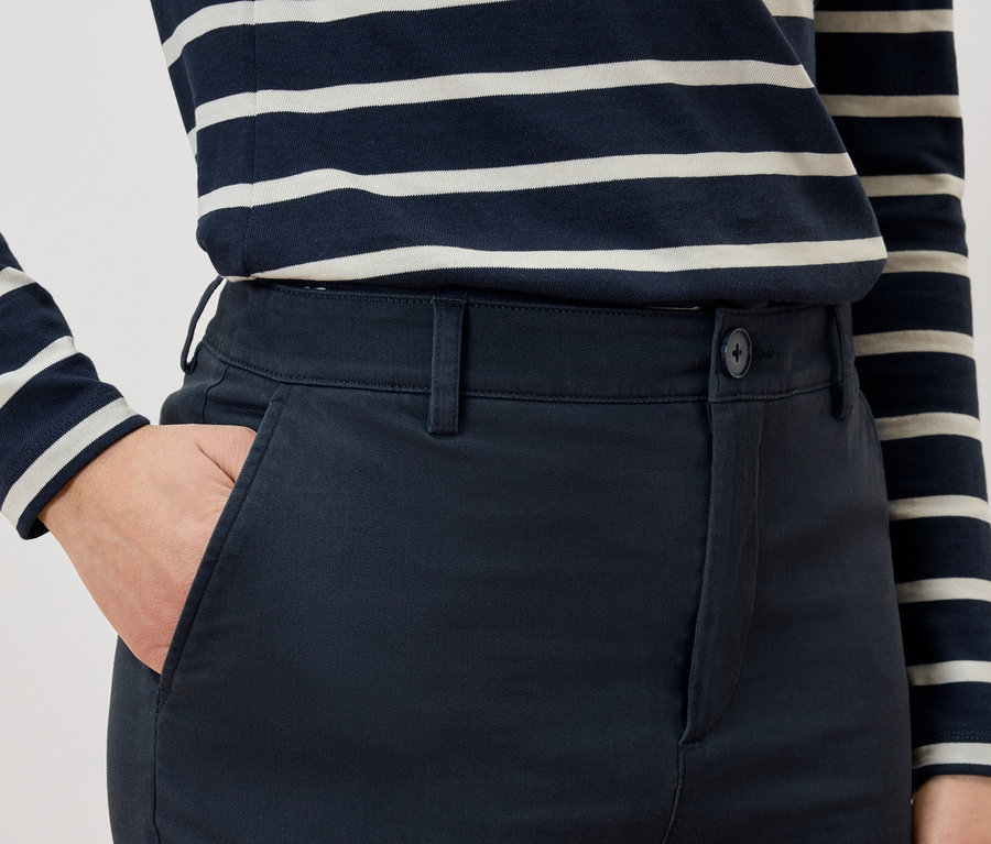 Zbliżenie osoby z ręką w kieszeni spodni i w bluzce w paski.