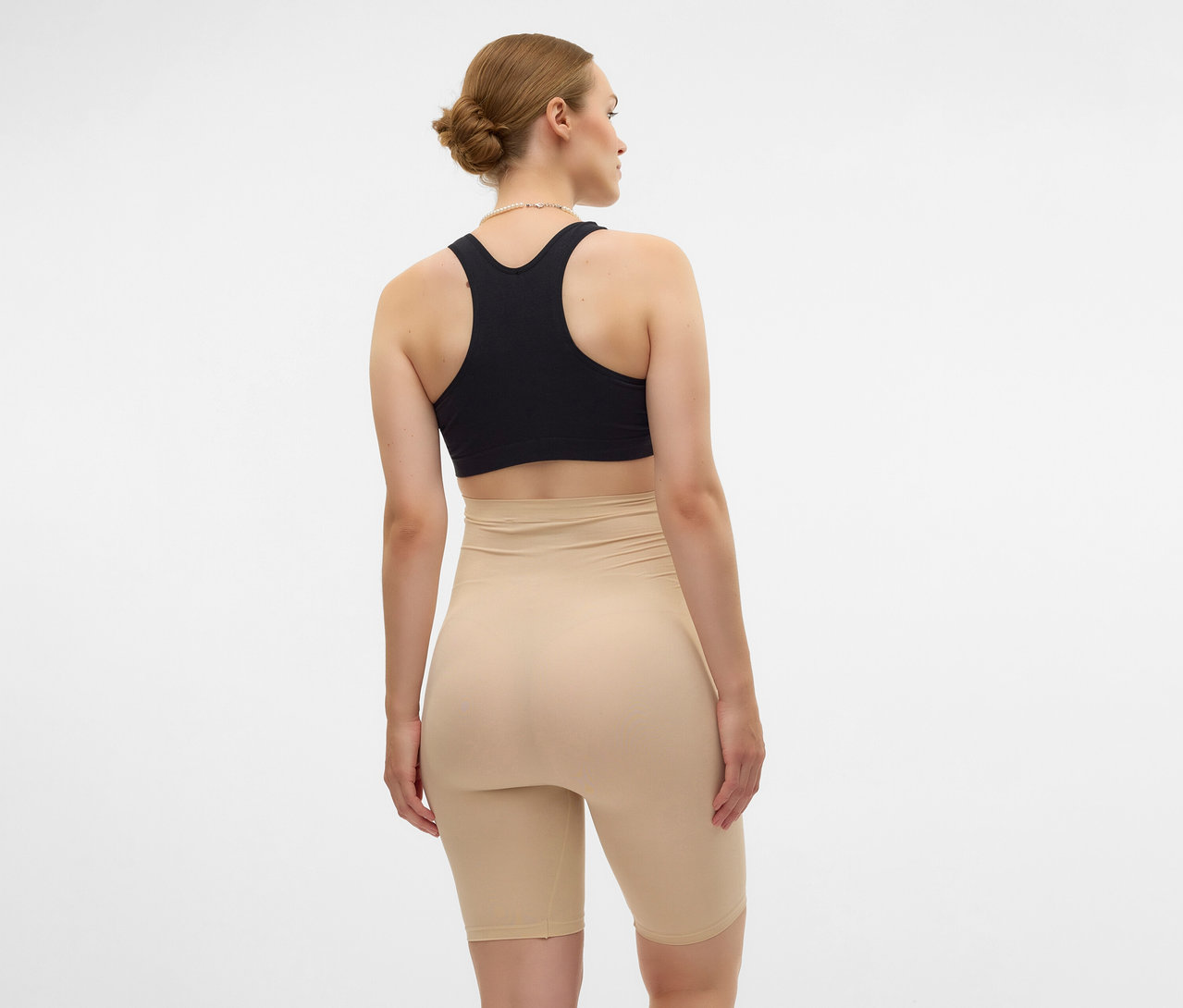 Kobieta z tyłu w czarnym staniku sportowym i czarnych szortach skinny MAMALICIOUS „MLTIA JEANNE”.