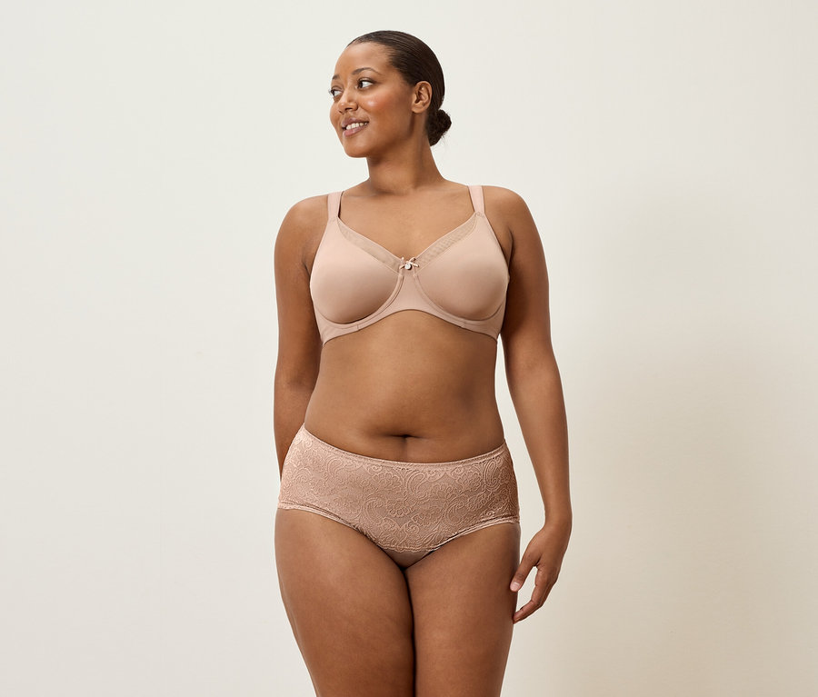 Kobieta ma na sobie beżowy biustonosz i koronkowe majtki.