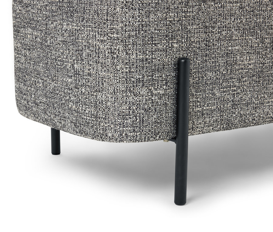 Zbliżenie rogu fotela z szarą, melanżową tkaniną i czarnymi nogami na białym tle.