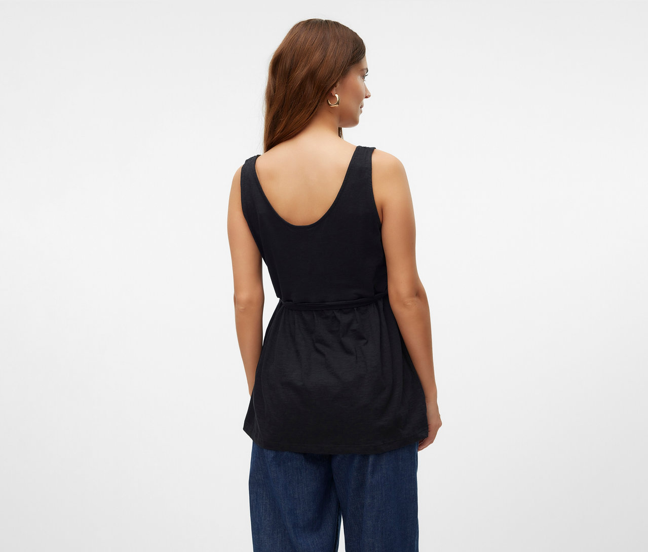 Kobieta od tyłu w topie do karmienia piersią MAMALICIOUS „MLEVI LIA” i niebieskich dżinsach.