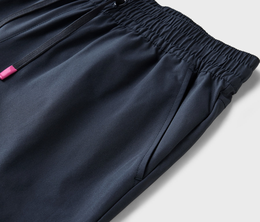 Szczegółowe ujęcie granatowych spodni z elastycznym pasem i sznurkiem