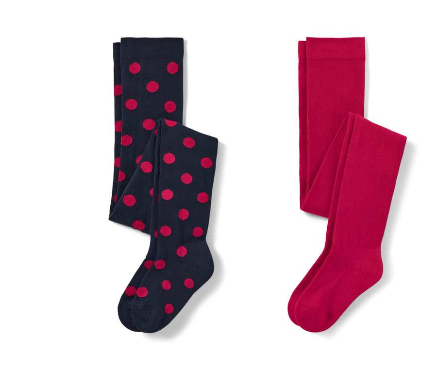 Dwie pary rajstop dziecięcych: jedna granatowa w czerwone kropki i jedna czerwona.
