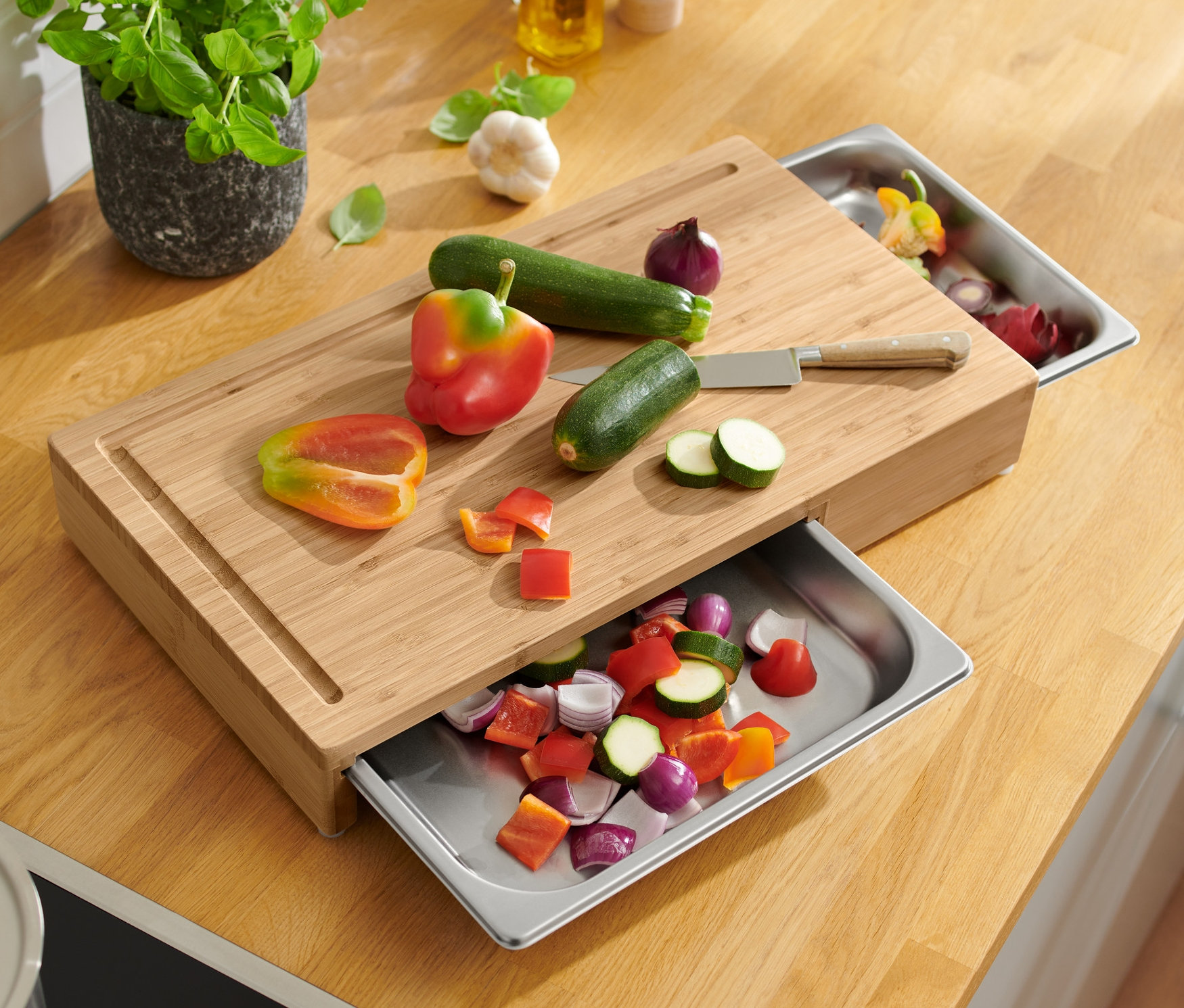 Warzywa pokrojone na desce do krojenia z tacami ze stali nierdzewnej.