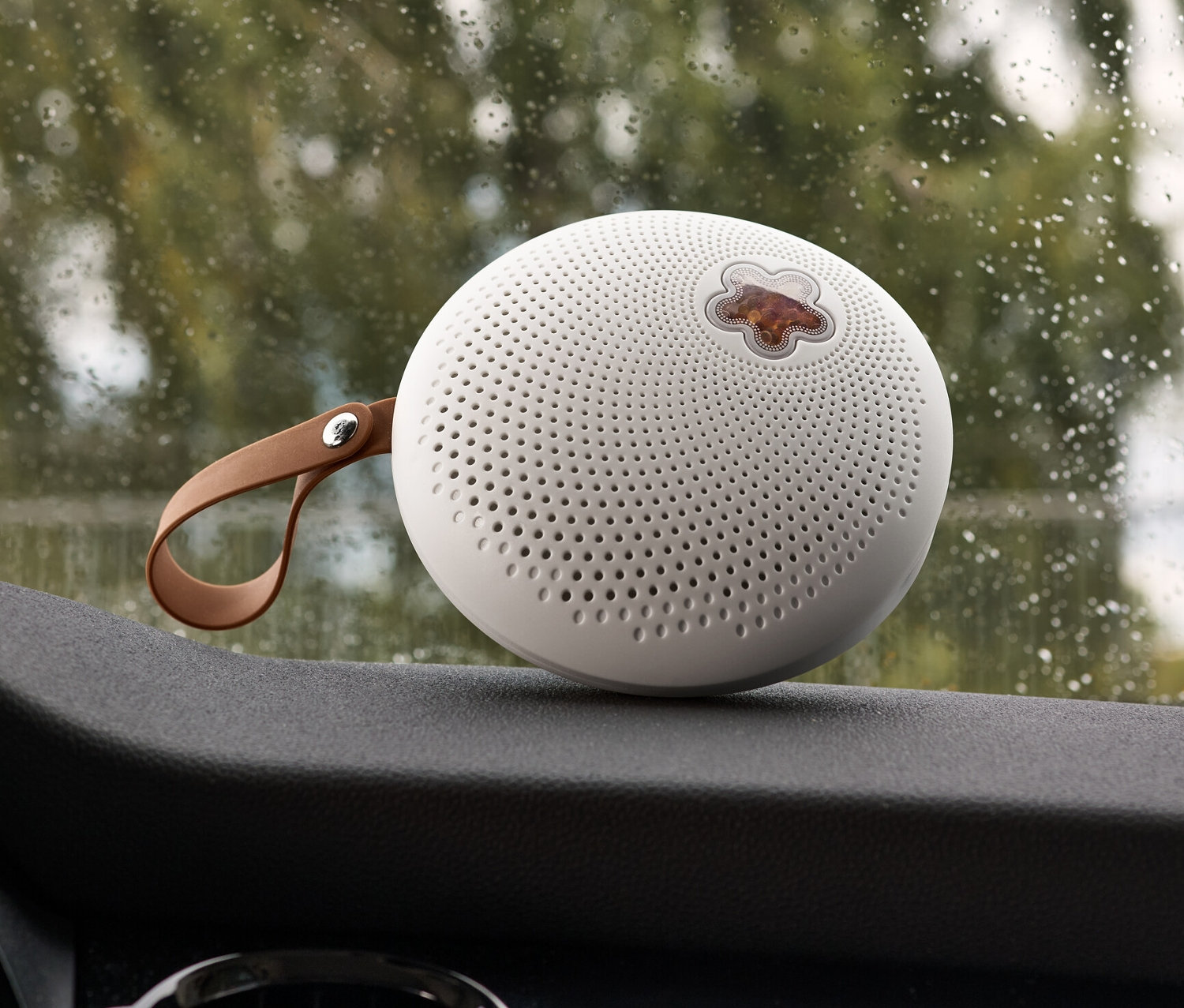 Przenośny osuszacz powietrza umieszczony na desce rozdzielczej samochodu.