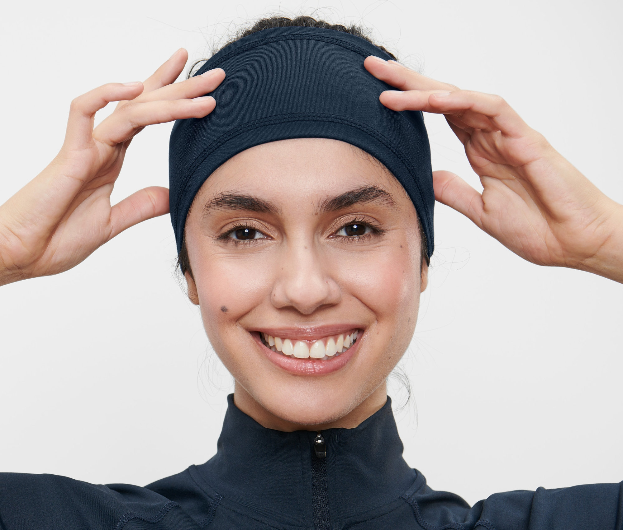 Kobieta poprawia sportową opaskę na czoło.