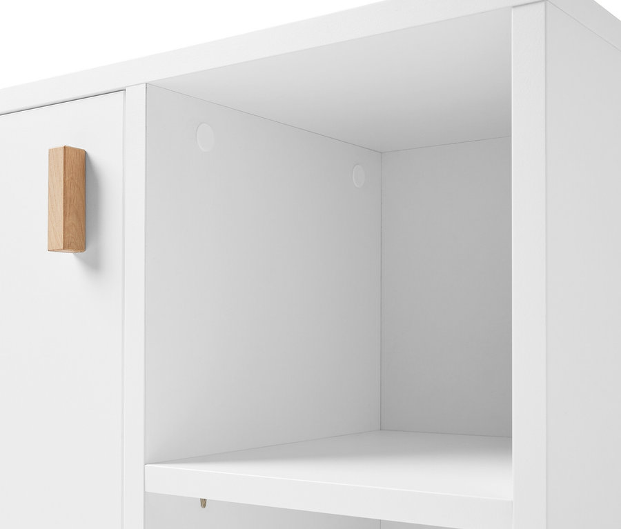 Detal białej szafki pod umywalkę z drzwiczkami i boczną przegródką.