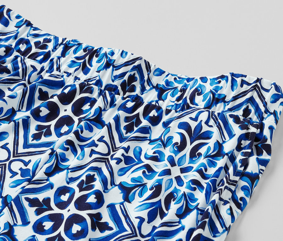 Zbliżenie na niebieskie, wzorzyste spodnie palazzo z elastycznym pasem.