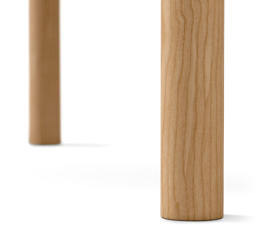 Szczegół dwóch jasnych, drewnianych nóg stołu na białym tle.