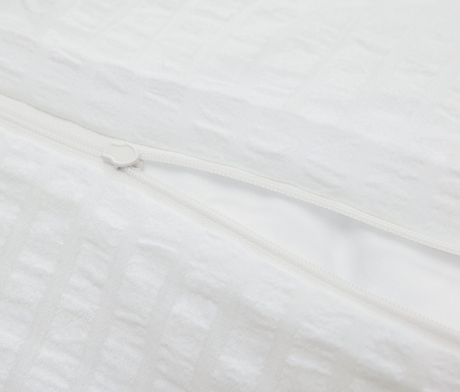 Zbliżenie na białą poszwę na kołdrę z zamkiem błyskawicznym.