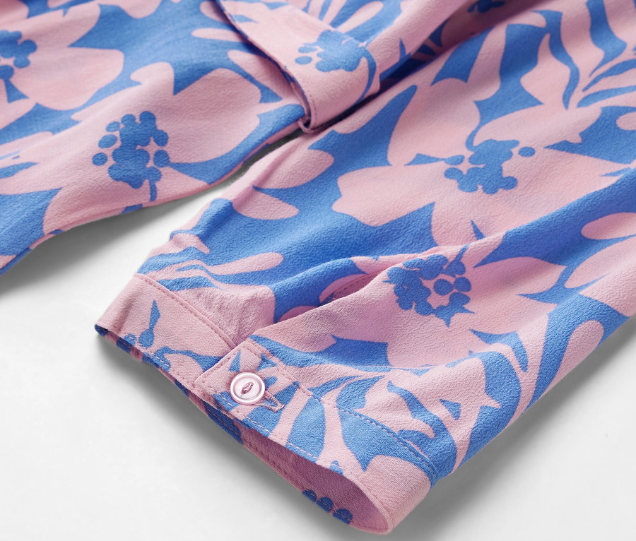 Detal wzorzystej sukienki koszulowej.