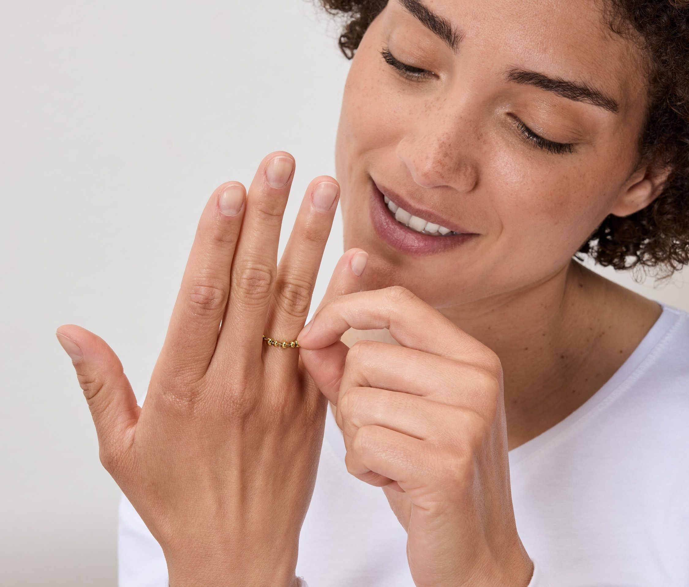 Kobieta ogląda złoty pierścionek na palcu.