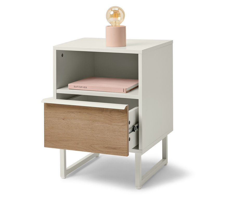 Biała szafka nocna z drewnianą szufladą i różową lampką.