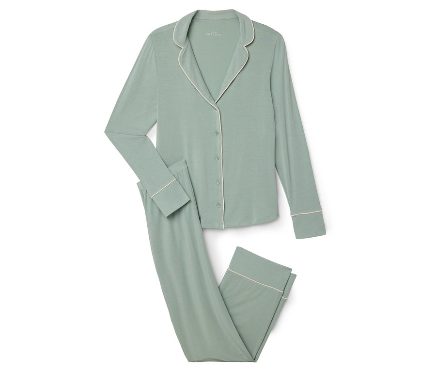 Zielona piżama z białym obszyciem leży na białym tle.