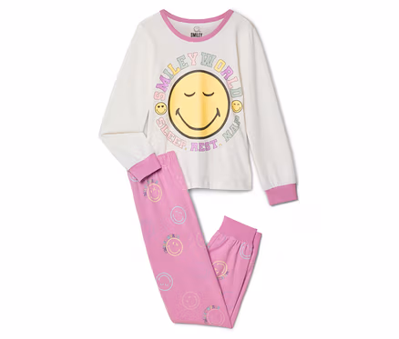 Piżama dziecięca SMILEYWORLD®: Kremowa bluzka z długim rękawem z dużym żółtym uśmiechniętym buziakiem i napisem „SMILEY WORLD SLEEP. REST. NAP.”, do tego różowe spodnie w małe pastelowe buźki.