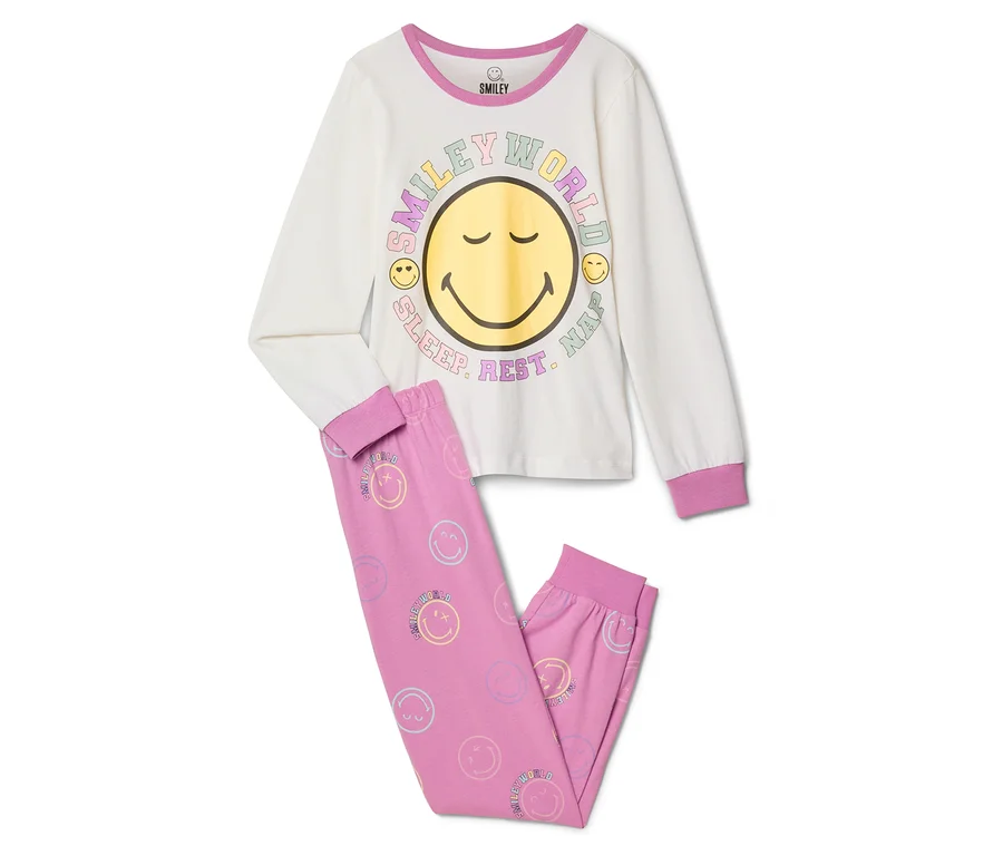 Piżama dziecięca SMILEYWORLD®: Kremowa bluzka z długim rękawem z dużym żółtym uśmiechniętym buziakiem i napisem „SMILEY WORLD SLEEP. REST. NAP.”, do tego różowe spodnie w małe pastelowe buźki.