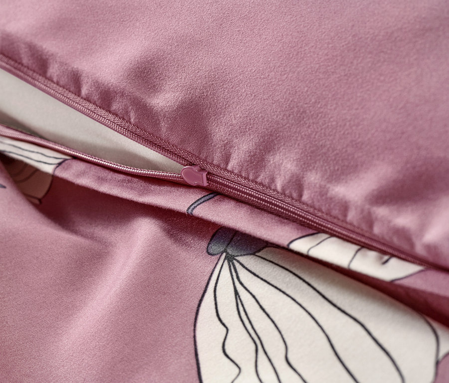 Zbliżenie na szaroróżową pościel z mikrowłókna z zamkiem błyskawicznym i kwiatowym wzorem.