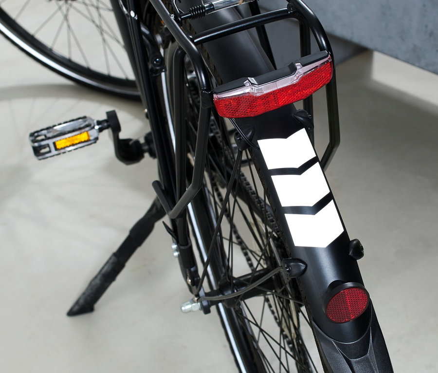 Zbliżenie na tylne koło roweru z 16 naklejkami odblaskowymi.