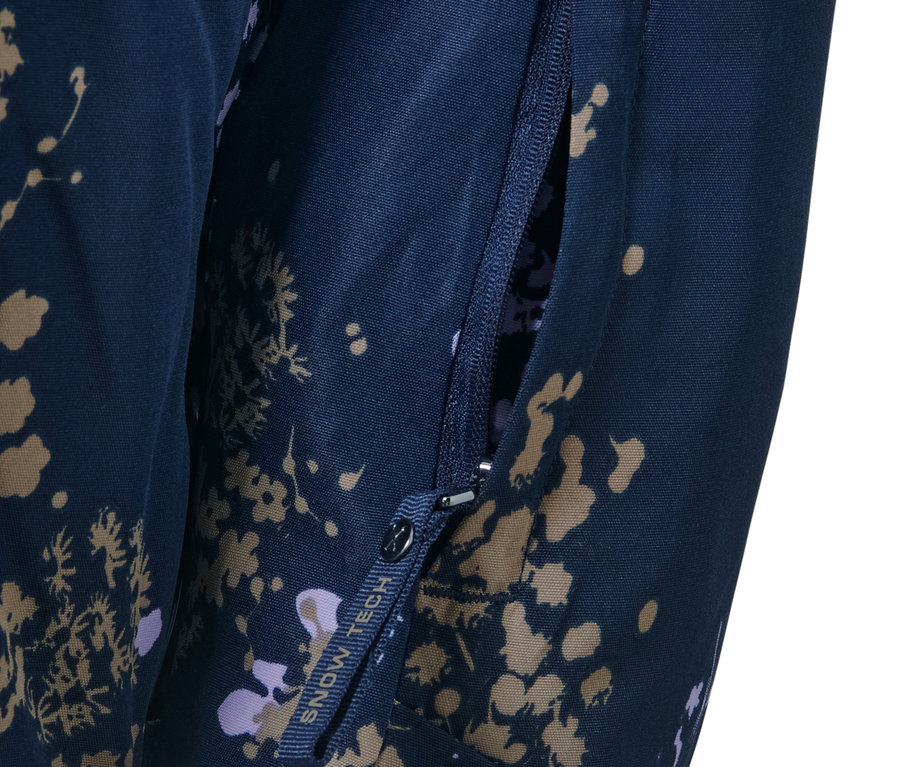 Szczegół kurtki narciarskiej z krótkim zamkiem błyskawicznym z otwartą kieszenią na zamek.