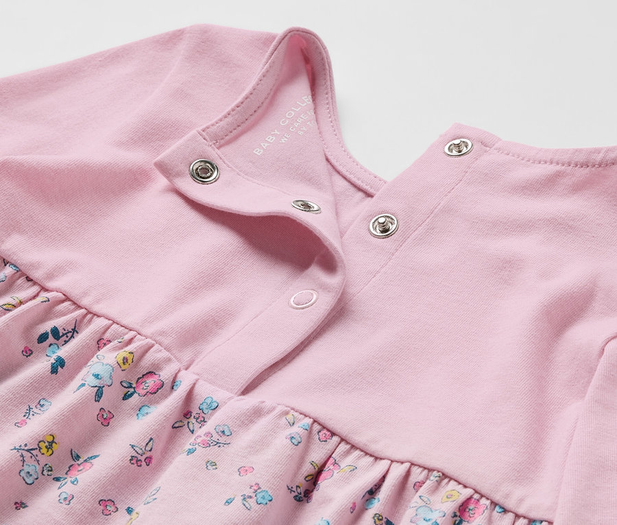 Zbliżenie na różową sukienkę dżersejową z kwiatowym wzorem.