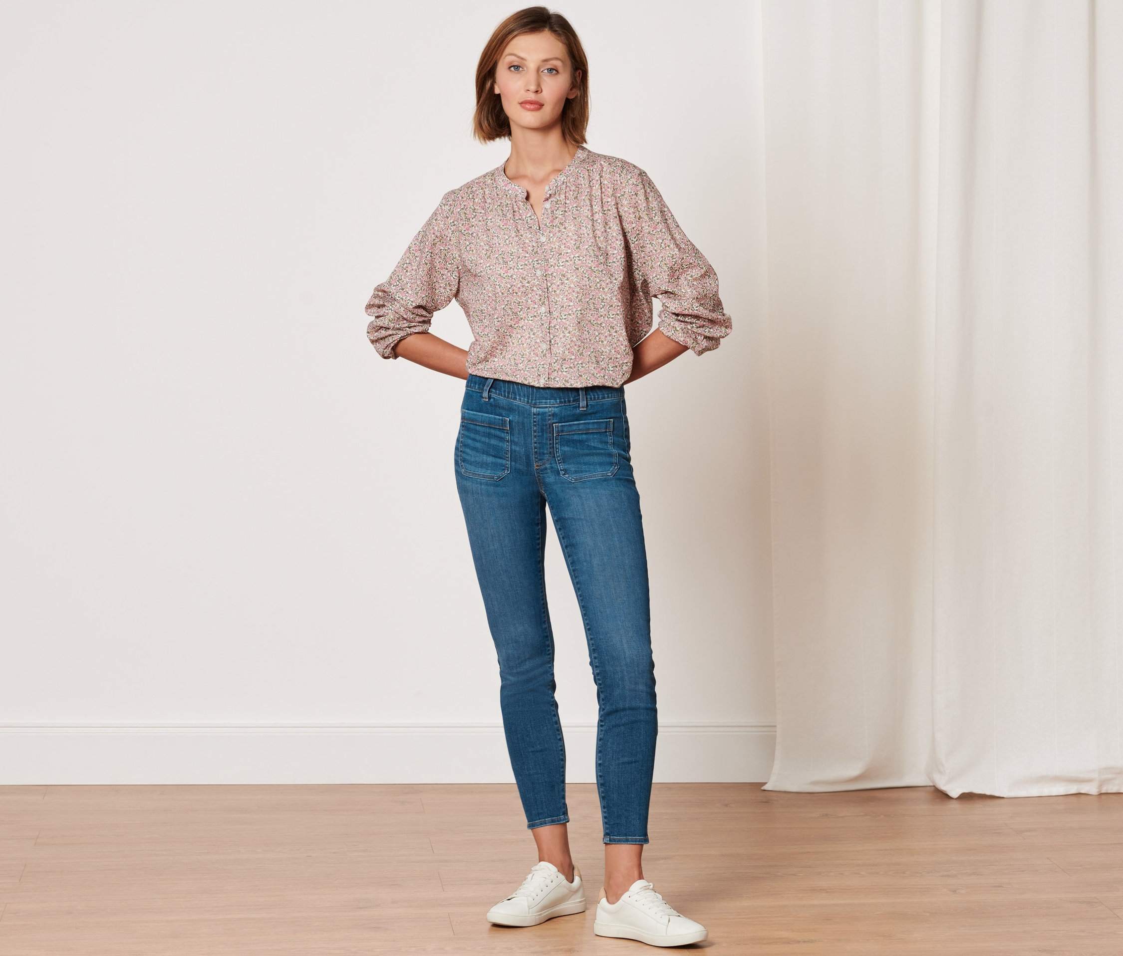 Kobieta pozuje w tregginsach »Fit Nelly« i wzorzystej bluzce.