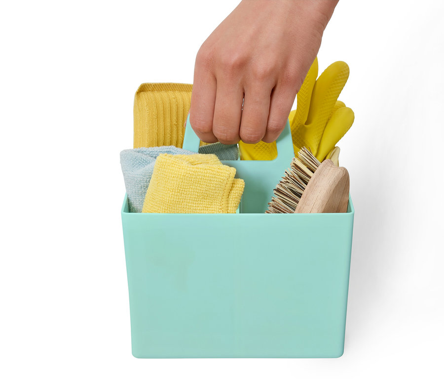 Ręka trzyma niebiesko-zielony pojemnik do przechowywania ze środkami czyszczącymi.