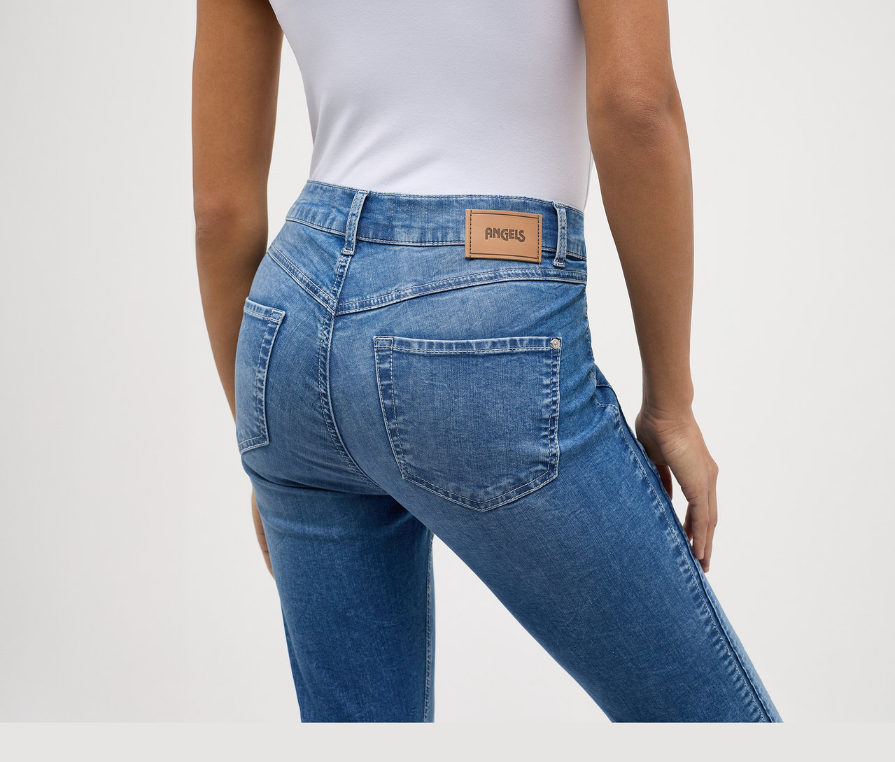 Widok z tyłu osoby w jasnoniebieskich dżinsach Angels „Ornella Seam” Slim Fit 7/8 i białym topie.