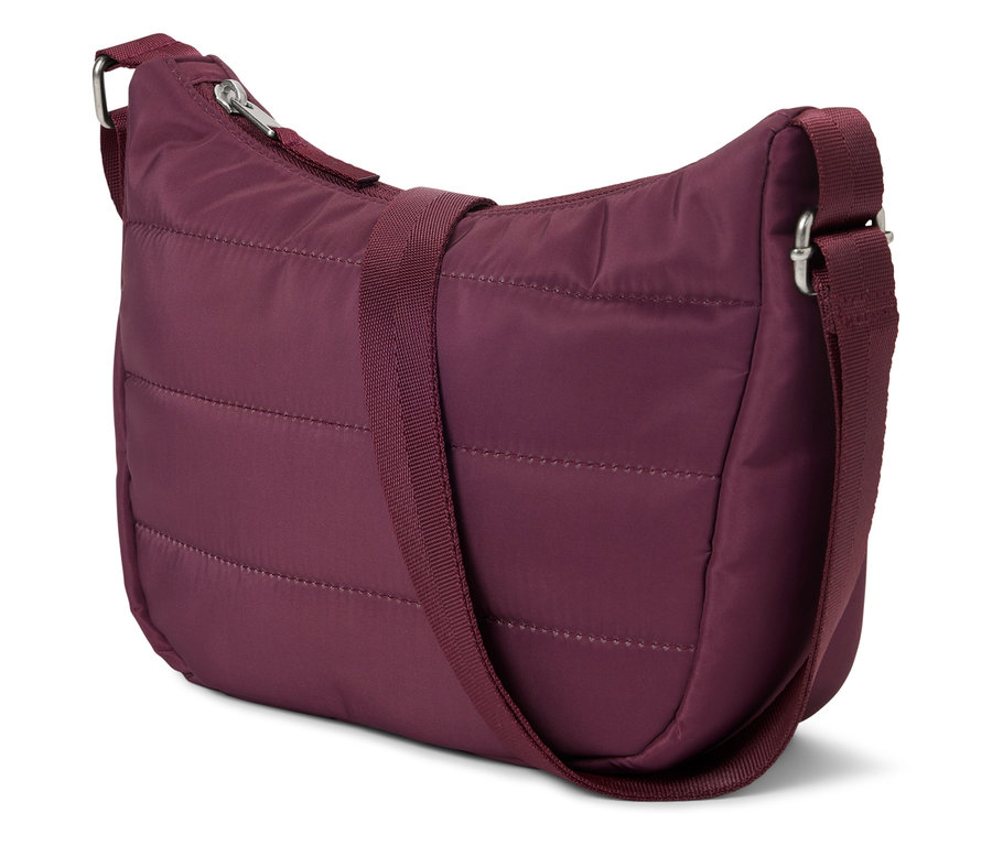 Burgundowa, pikowana torebka z regulowanym paskiem na ramię leży na białym tle.