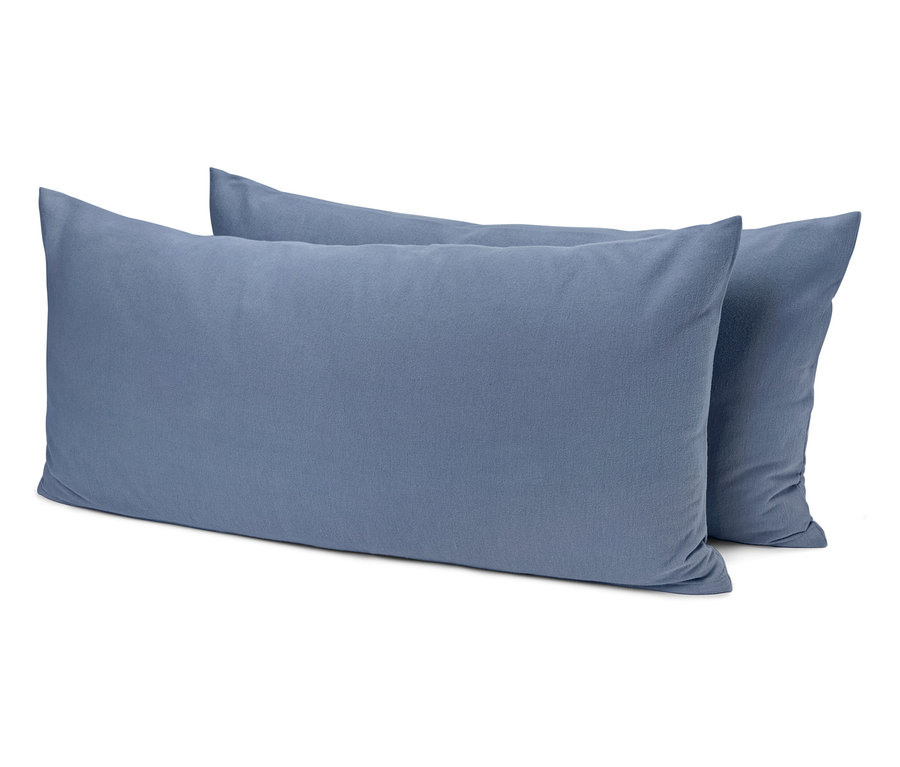 Dwie niebieskie poduszki leżą na sobie.