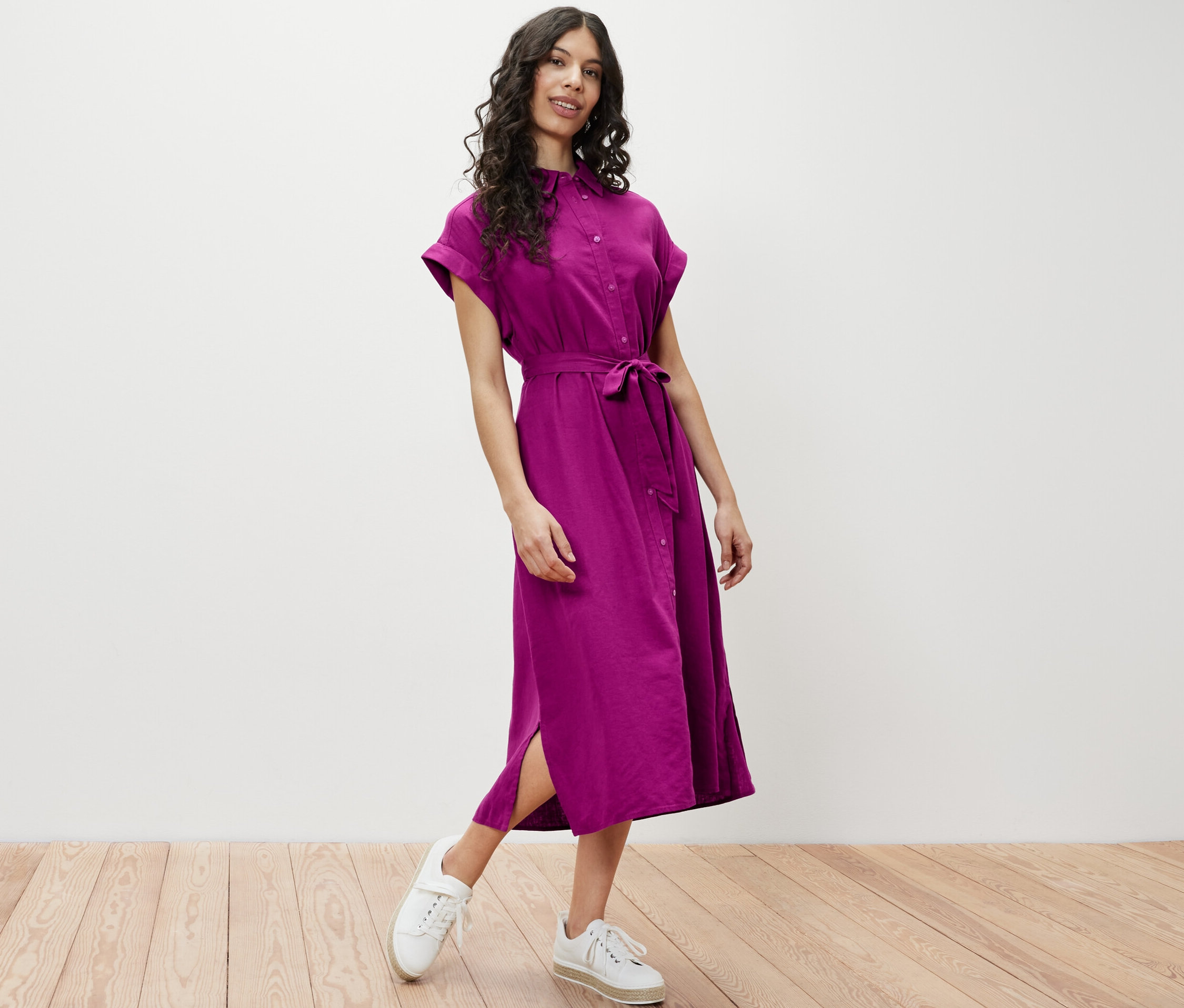 Kobieta pozuje w lnianej sukience.