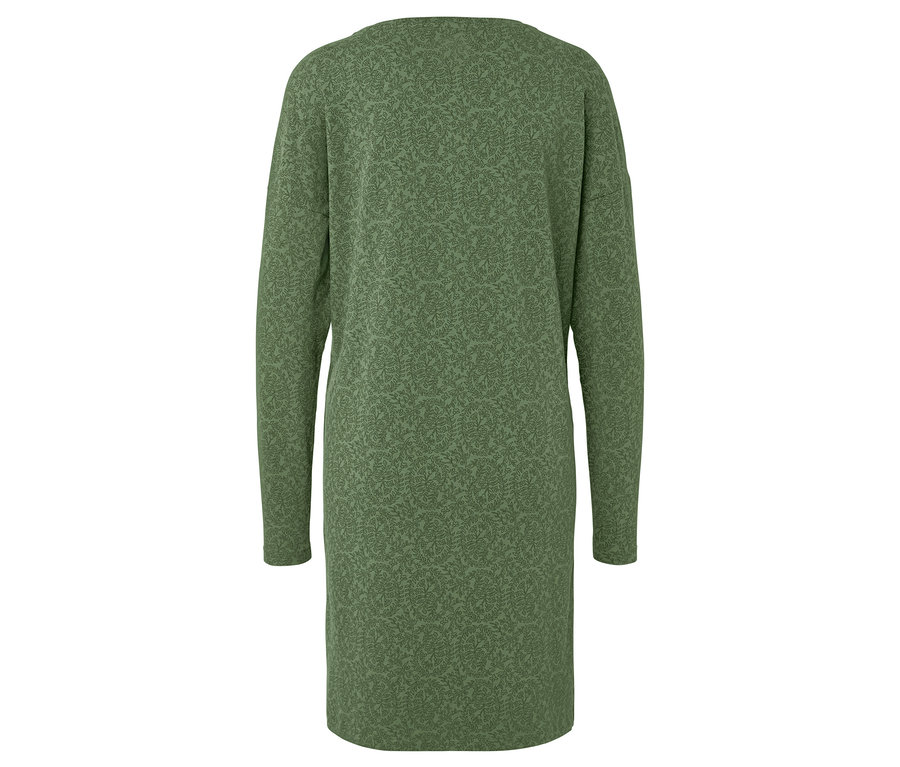 Z tyłu widać zieloną sukienkę z długimi rękawami i nadrukiem w liście.