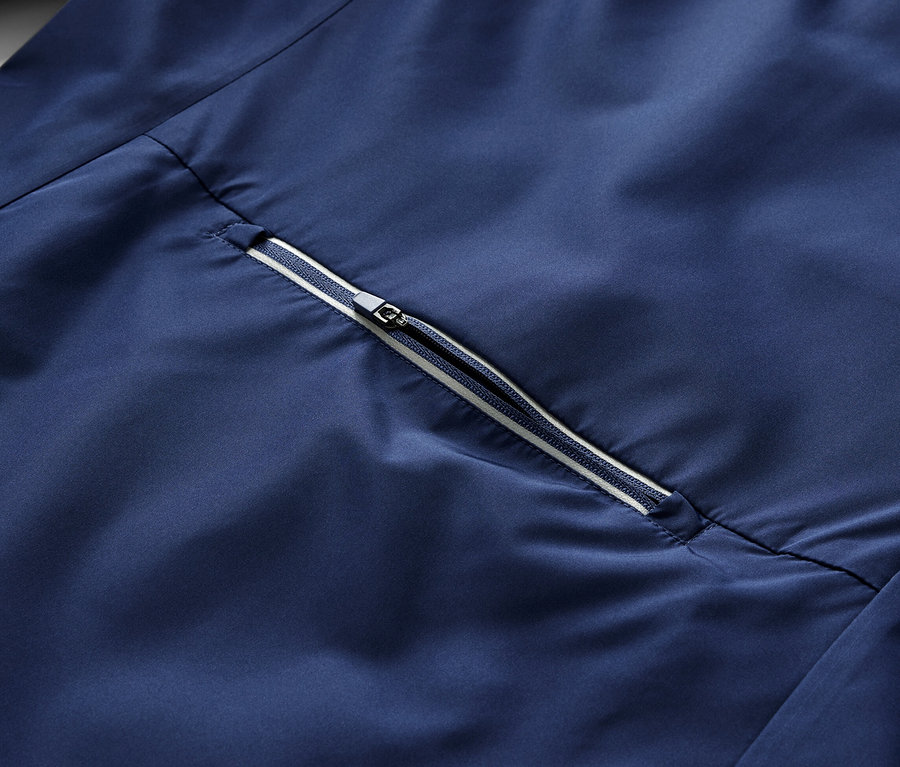 Szczegół niebieskiej kurtki rowerowej 2 w 1 z zamkiem błyskawicznym.